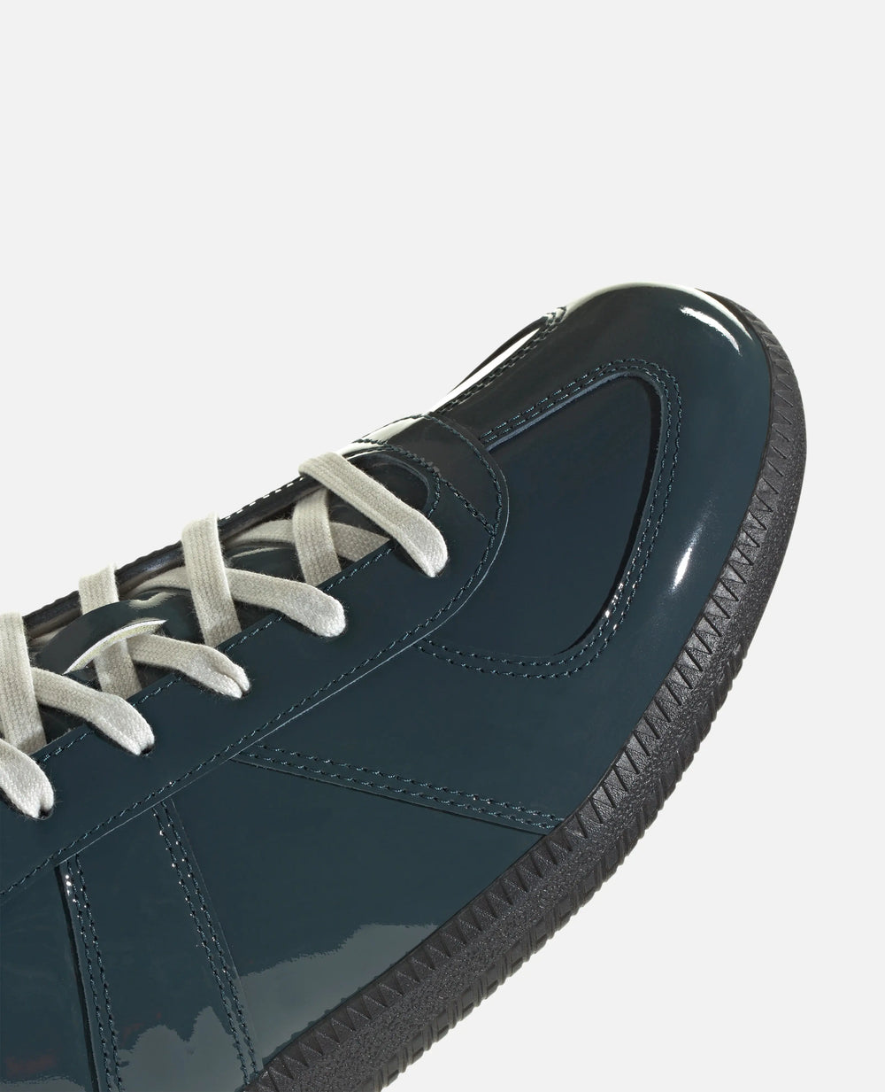 Close-up detail of the glossy patent upper and laces on the adidas BW Army sneaker.