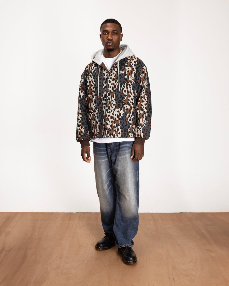 full body model shot of the leopard side of the reversible bomber jacket styled with blue jeans and boots