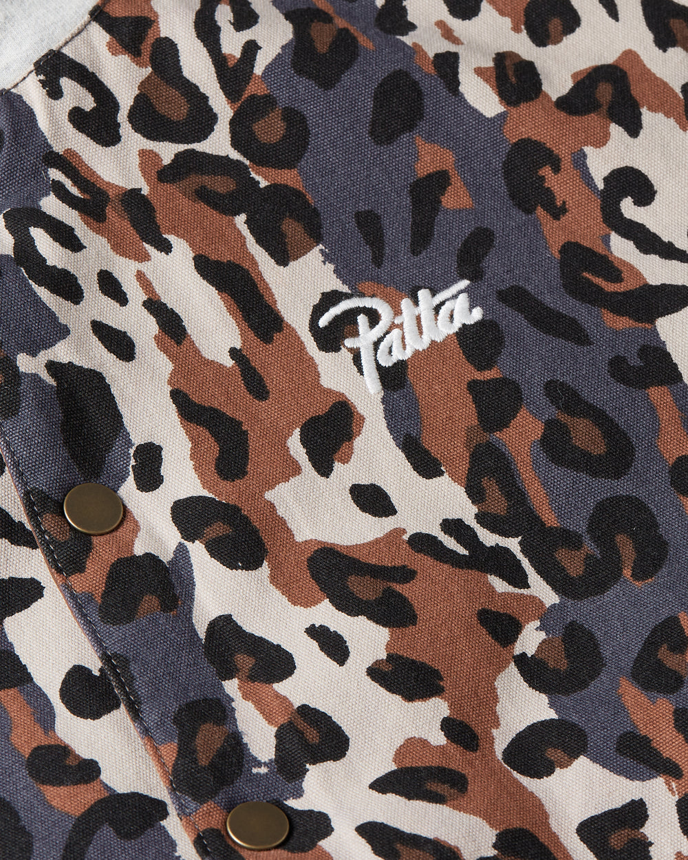 close up detail shot showing the leopard allover print and an embroidered patta script logo